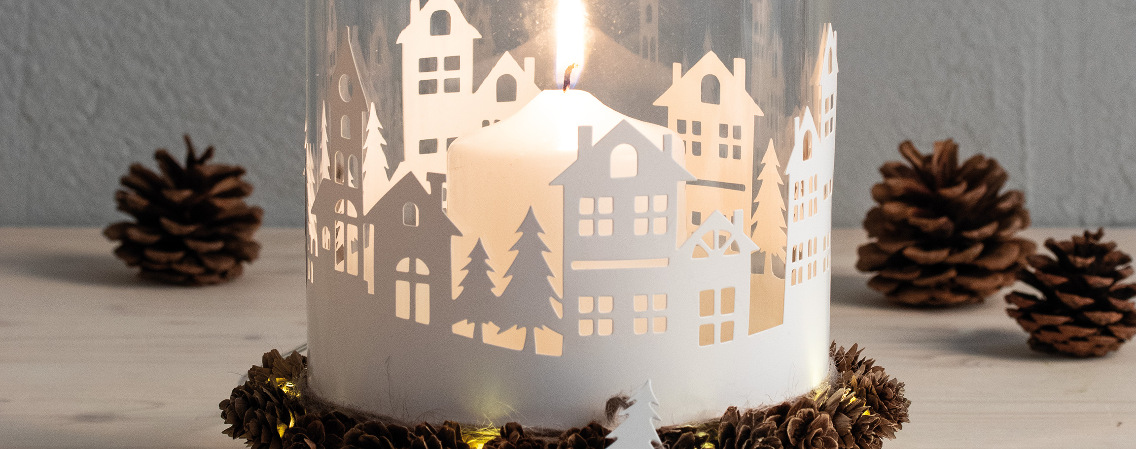 Glass candle jar with paper silhouettes mountain village