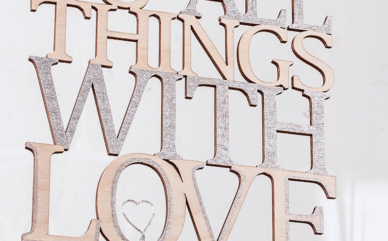 Metallring mit Holzschrift „Do more of what makes you happy“